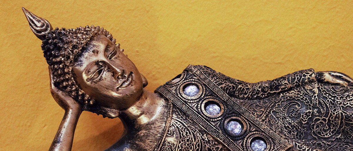 Buddhafigur liegend Buddhafigur liegend mit Kerzen im Vordergrund