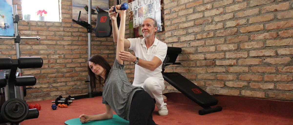 Bewegungstraining Dr. Kögler trainiert mit einer jungen Frau die Arme